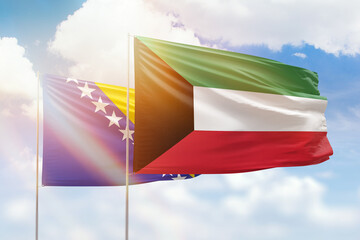 Sunny blue sky and flags of kuwait and bosnia