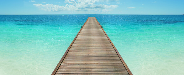 Wooden jetty in the turquoise indian ocean. way to vacation.