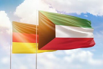 Sunny blue sky and flags of kuwait and germany