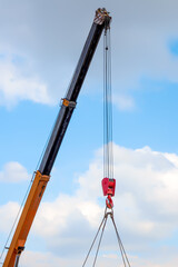 A crane boom raised high against the sky
