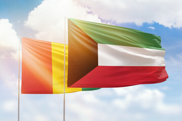 Sunny blue sky and flags of kuwait and guinea