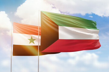 Sunny blue sky and flags of kuwait and syria
