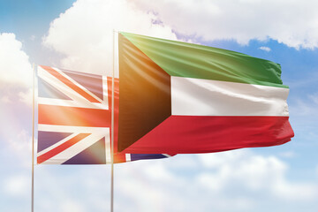 Sunny blue sky and flags of kuwait and united kingdom