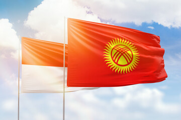 Sunny blue sky and flags of kyrgyzstan and indonesia