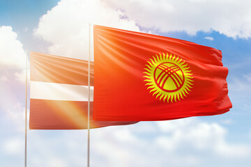 Sunny blue sky and flags of kyrgyzstan and latvia