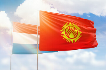 Sunny blue sky and flags of kyrgyzstan and luxembourg