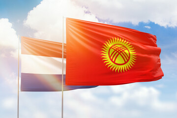 Sunny blue sky and flags of kyrgyzstan and netherlands