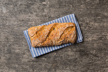 Fresh loaves of bread with wheat and gluten on a colored table. bread on napkin on rustic background, fresh bread top view