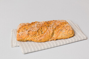 freshly baked bread with napkin on rustic table top view. Healthy white bread loaf isolated