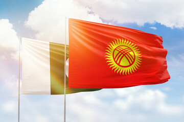 Sunny blue sky and flags of kyrgyzstan and pakistan