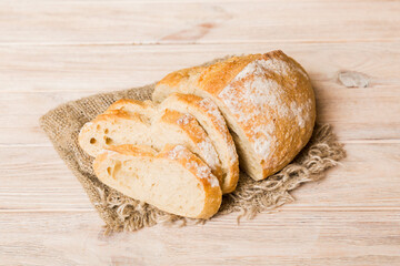 Assortment of freshly sliced baked bread with napkin on rustic table top view. Healthy unleavened bread. French bread slice