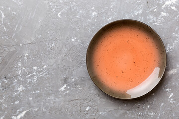 Top view of empty red plate on cement background. Empty space for your design