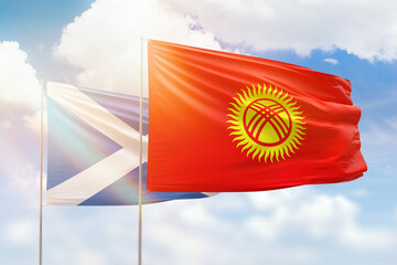 Sunny blue sky and flags of kyrgyzstan and scotland