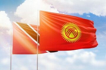 Sunny blue sky and flags of kyrgyzstan and trinidad and tobago
