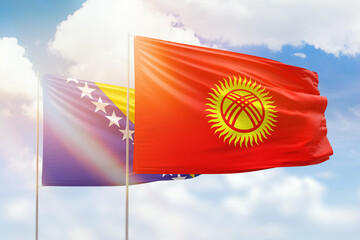 Sunny blue sky and flags of kyrgyzstan and bosnia