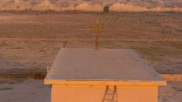 Old metal cross on top of abandoned structure in desert sunset, aerial

Aerial view over Qasr al-Yahud or The land of the monasteries, israel,2022
