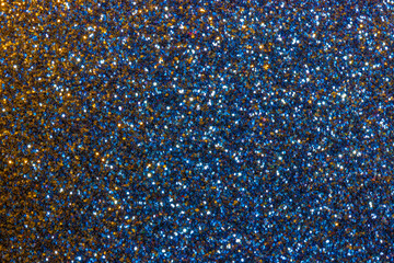 Blue and yellow sparkle abstract background. Macro sparkle creates mysterious glitter background effect.