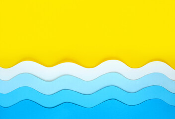 Seashore made of color paper. Yellow beach sand background with copy space and paper cut blue waves...