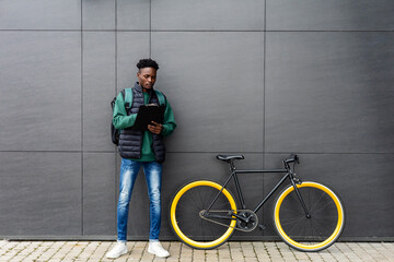 Delivery young man with bicycle fills out paperwork.
