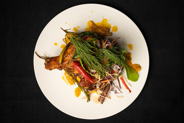 plate with grilled chicken with potatoes, salad on top and chili seen from above
