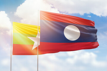 Sunny blue sky and flags of laos and myanmar