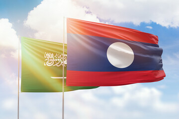 Sunny blue sky and flags of laos and saudi arabia