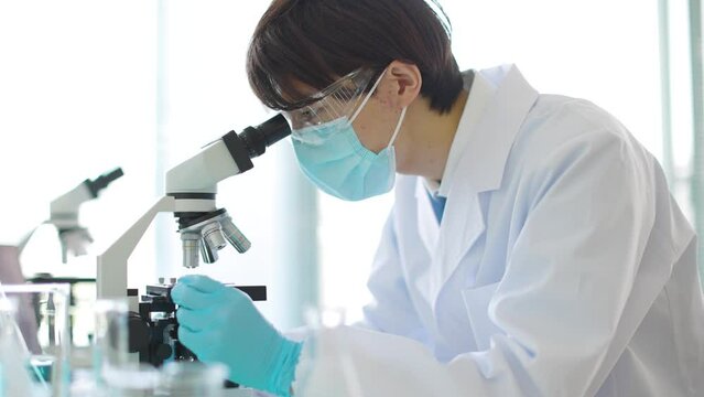 顕微鏡を覗く研究者