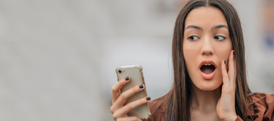 surprised girl looking at mobile phone or smartphone