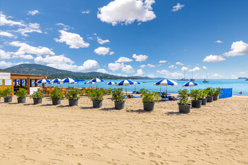 Chairs, lounges and umbrellas along the French Riviera at the sandy beach of Port Grimaud, France,...