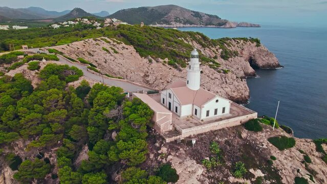 Scenic view of a Lighthouse during sunrise on a rocky coastline from above. Far de Capdepera in Carrer de sa Comassa, Majorca, Balearic Islands, Spain, the Lighthouse is Mallorca's easternmost point.