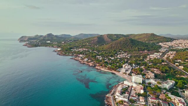 Beautiful landscape beach on Majorca Island in Spain with Hotels and Resorts. Cala Son Moll Beach - early morning drone view from above of the Spanish East Coastline Balearic Islands.