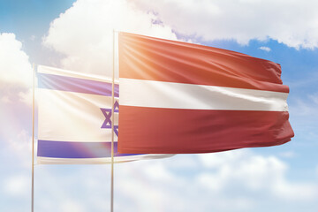 Sunny blue sky and flags of latvia and israel