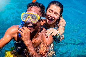 Interracial couple having fun on a day at the beach and enjoying the summer