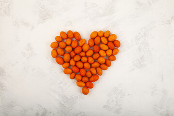 Coated Peanut laid out in the shape of heart on grey background.  Design element. Delicious crispy...