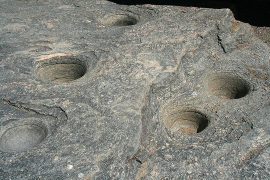 Pre-Columbian mortars carved in stone. Multiple mortar. Sacred City of the Quilmes. Native people of Argentina, Latin America. pre-Columbian culture. Agriculture. Kitchen tool. Carved stone. 
Utensil