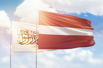 Sunny blue sky and flags of latvia and afghanistan