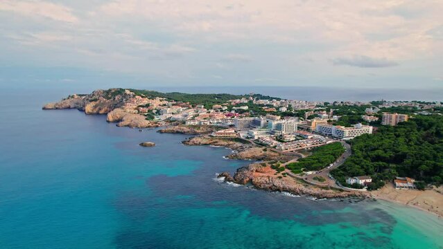 Aerial top view of Spanish mansions, resorts and spas, restaurants and hotels. Panoramic view of Cala Agulla, Es Pelats and Cala Lliteres towns with blue water on Majorca, Balearic Islands, Spain