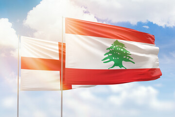 Sunny blue sky and flags of lebanon and england