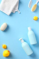 Baby shampoo, shower gel and accessories for bathing on blue background