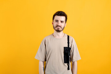 Caucasian man wearing beige tee posing isolated over yellow background crying wipes tears losing...