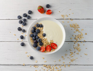 breakfast of yogurt and fresh strawberries and blueberries flat lay