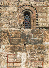 A tiny reinforced window on a medieval church