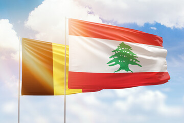 Sunny blue sky and flags of lebanon and belgium