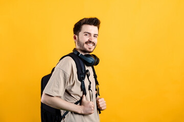 Cheerful caucasian man wearing casual clothes posing isolated over yellow background posing education in high school university college concept.