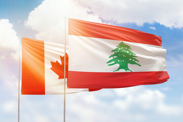 Sunny blue sky and flags of lebanon and canada