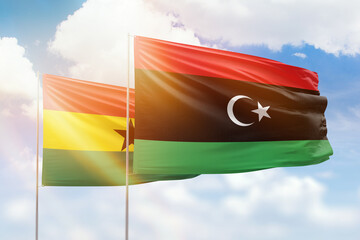 Sunny blue sky and flags of libya and ghana