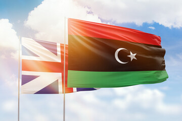 Sunny blue sky and flags of libya and great britain