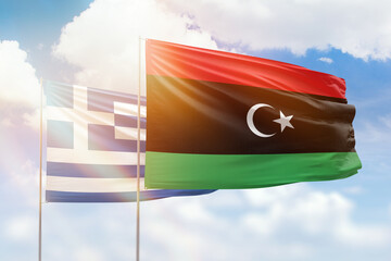 Sunny blue sky and flags of libya and greece