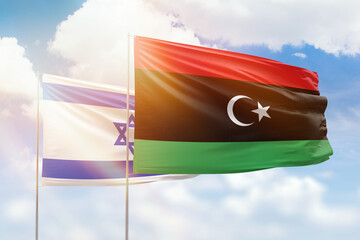 Sunny blue sky and flags of libya and israel