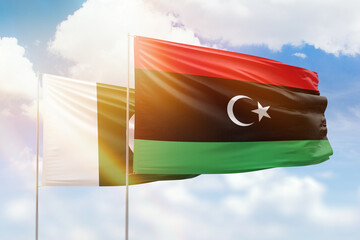 Sunny blue sky and flags of libya and pakistan